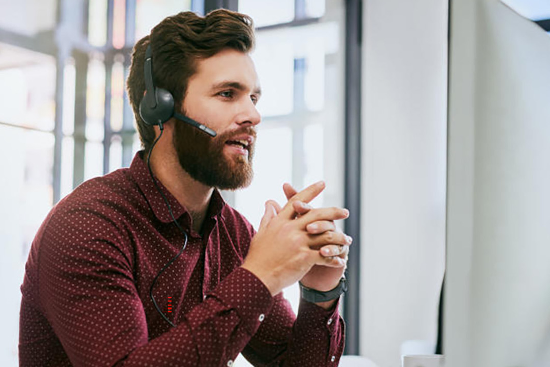 Servicemitarbeiter-mit-braunen-Haaren-und-Headset-am-Computer