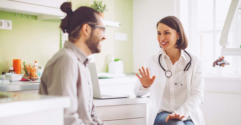 Ärztin und Mann sprechen im Behandlungszimmer