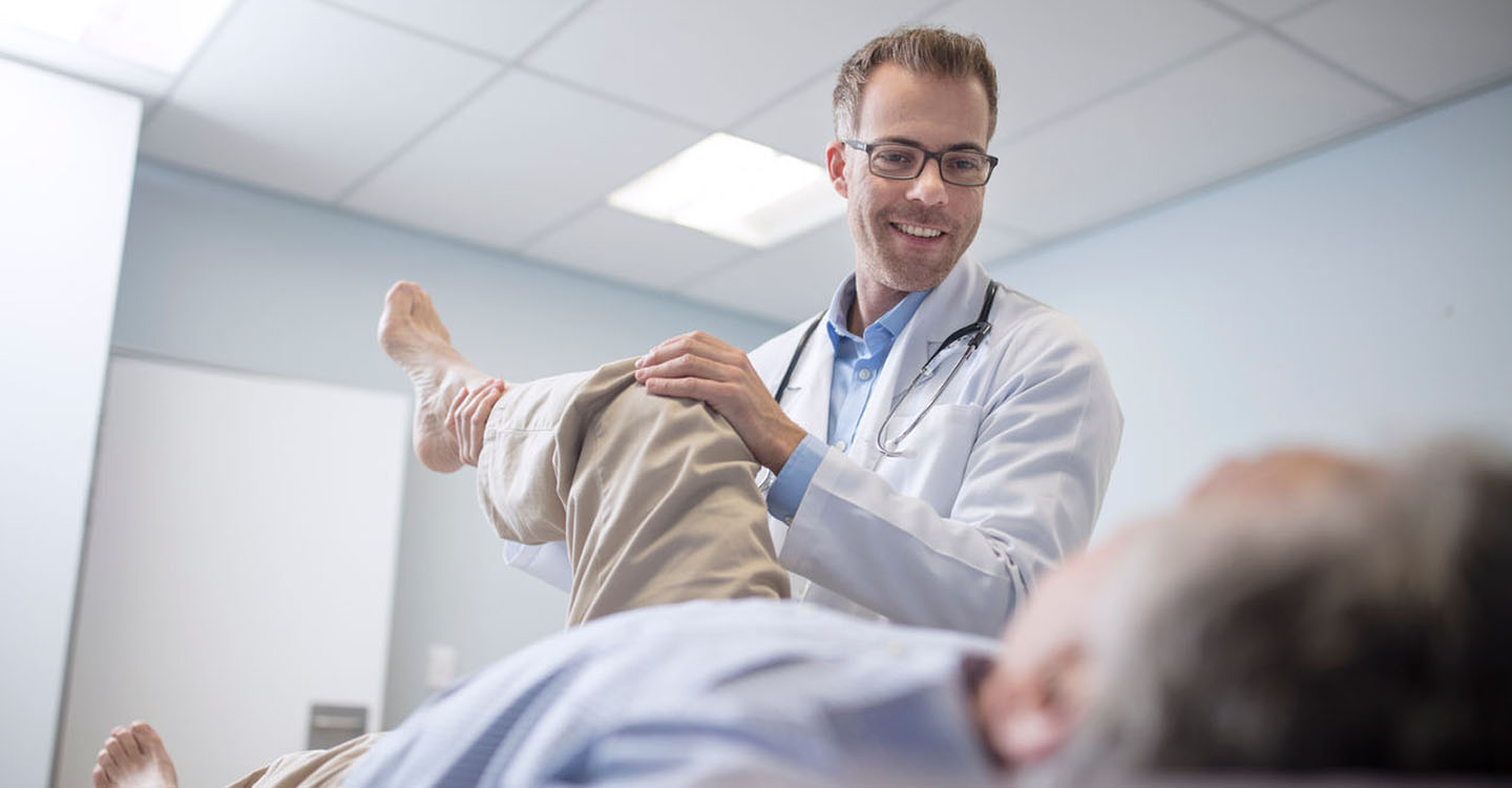 Arzt bei einer osteopathische Knie Behandlung