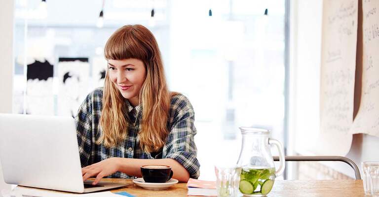 Frau im Kaffee arbeitet an einem Laptop