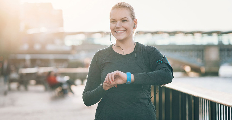 Joggerin schaut auf ihre Sportuhr