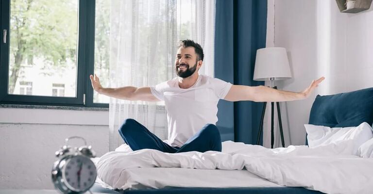 Eine Frau sitzt auf einem Sofa und schaut auf Ihr Smartphone