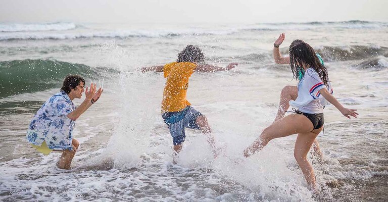 Teenager toben mit dem Füßen im Meer