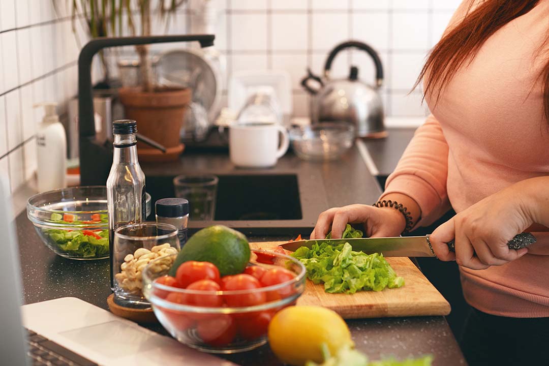 Eine Frau schneidet Gemüse in der Küche